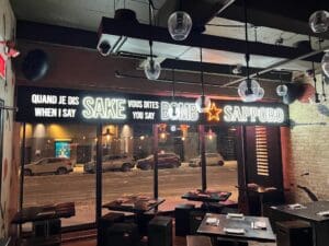 Front of restaurant with sign that says "When I say SAKE you say BOMB" and "Sapporo"