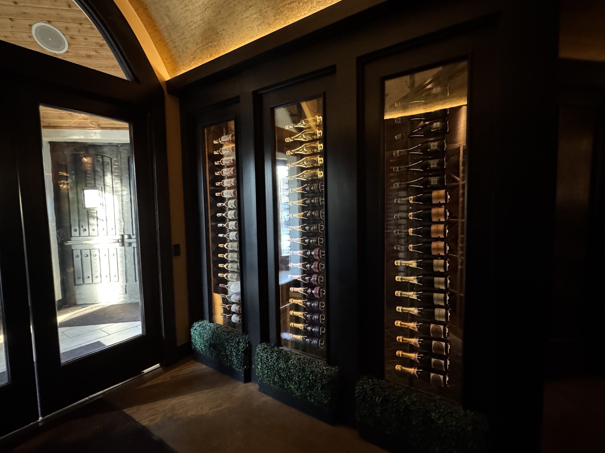 Entrance to Next Door by Wegmans with Wine bottles behind glass.